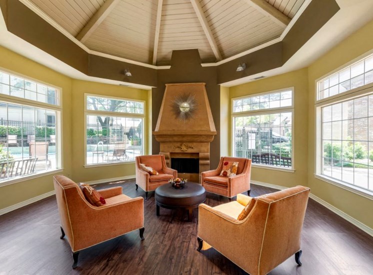 Clubhouse interior with arched ceilings, orange accent chairs, green accent walls, and large windows